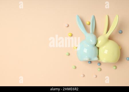 Easter bunnies on beige background, space for text Stock Photo