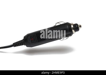 close up of charger for charging cell phone in car black connector for connecting electrical devices to cigarette lighter in vehicle on white backgrou Stock Photo