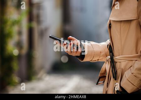 Woman checking her smart phone at city street. City life Stock Photo