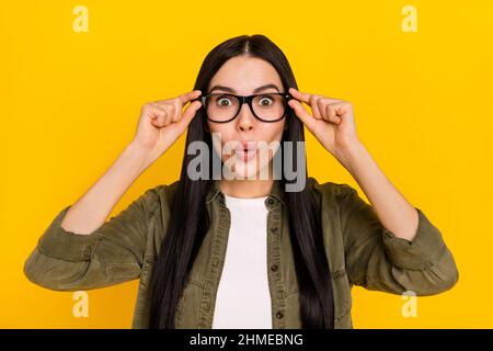 Photo of impressed millennial lady wear spectacles khaki outfit isolated on yellow color background Stock Photo
