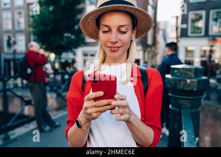 Smiling female traveler messaging on smartphone during tour Stock Photo