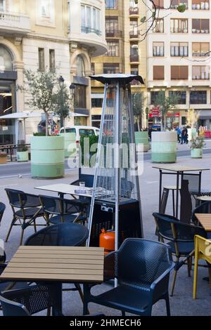 Terrace of a bar, restaurant or cafe in a big city that has a gas stove so that customers sitting at tables outside do not get cold in winter Stock Photo