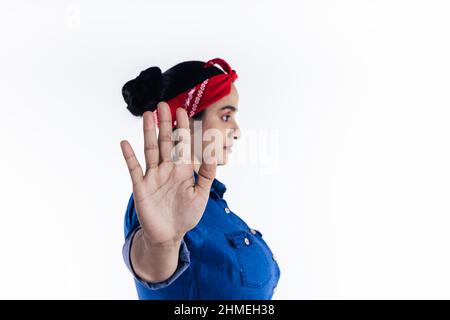 Hispanic woman raising her hand in stop concept, on white background. Stock Photo