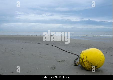 La plage de Bray-Dunes entre maree basse et maree haute. Bouee jaune sur la plage A yellow buoy on the Bray-Dunes beaches between high and low tide. Stock Photo