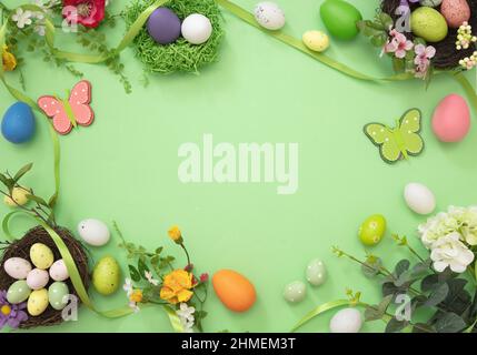 Easter flat lay. Egg nest, flower and season decoration on pastel green background, top view, copy space. Spring Holiday celebration Stock Photo
