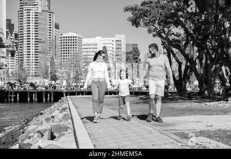 happy young mom and dad walking in park with son, adoption Stock Photo