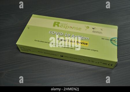 Ottawa, Ontario, Canada - February 9, 2022: The box for a Rapid Response COVID-19 antigen rapid test device lies on a wooden table. Stock Photo