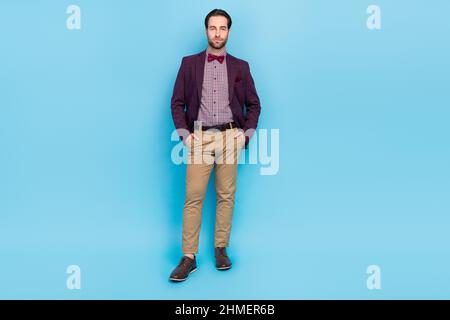 Full size photo of young guy intelligent hands in pocket expert investor employee isolated over blue color background Stock Photo