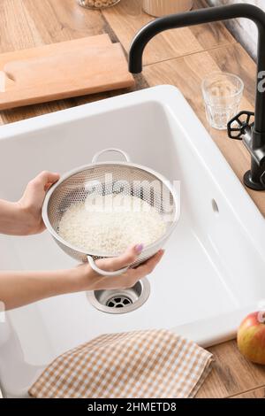 Raw white rice in a colander strainer isolated on white background ...