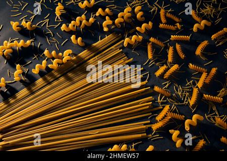 Pattern with difference types of pasta and spaghetti on black background.  Italian cuisine concept. Stock Photo