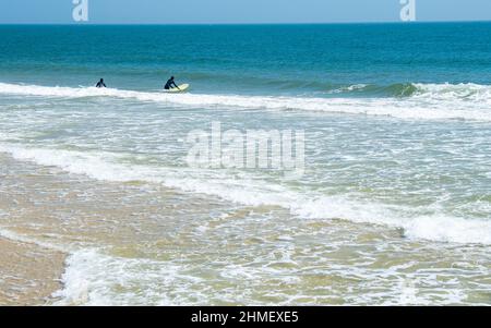 Surfers in landscape at Sea Girt beach in New Jersey USA Stock Photo