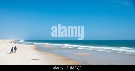 Surfers in landscape at Sea Girt beach in New Jersey USA Stock Photo