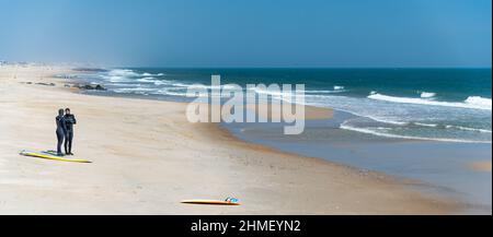 Surfers in landscape at Sea Girt beach in New Jersey USA Stock Photo