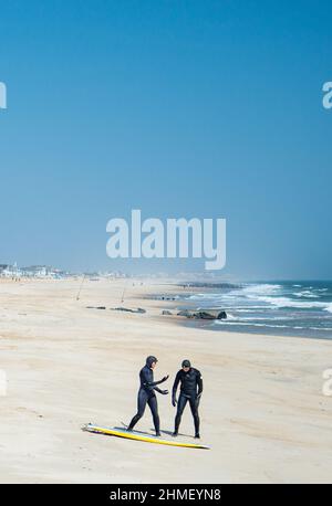 Surfers in landscape at Sea Girt beach in New Jersey USA Stock Photo