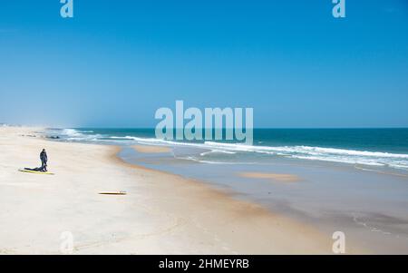 Surfers in landscape at Sea Girt beach in New Jersey USA Stock Photo