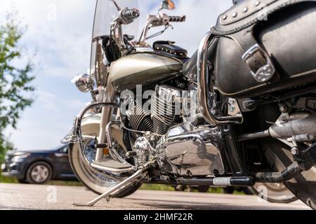 Classic motorcycle in the parking lot on a sunny day, side view from behind. Stock Photo