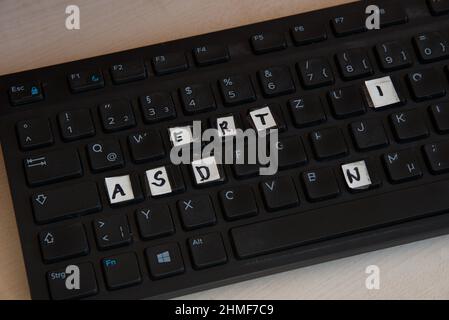 A computer keyboard with keys covered in letters Stock Photo
