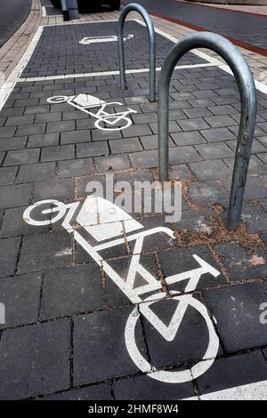 Parking for cargo bikes. A symbol painted on the sidewalk shows a cargo bike next to a mounting bracket. Hanover, Germany, February 5, 2022   ---  Parkplatz für Lastenräder. Ein auf den Bürgersteig gemaltes Symbol zeigt ein Lastenfahrrad neben einem Befestigungsbügel. Hannover, 5.2.2022 Stock Photo