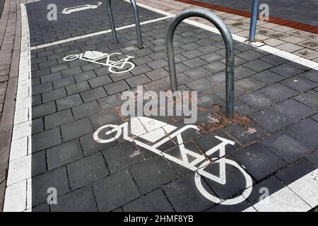 Parking for cargo bikes. A symbol painted on the sidewalk shows a cargo bike next to a mounting bracket. Hanover, Germany, February 5, 2022   ---  Parkplatz für Lastenräder. Ein auf den Bürgersteig gemaltes Symbol zeigt ein Lastenfahrrad neben einem Befestigungsbügel. Hannover, 5.2.2022 Stock Photo