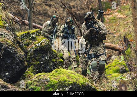 Battle ready armed ammunition squad sneaking into enemy territory Stock Photo