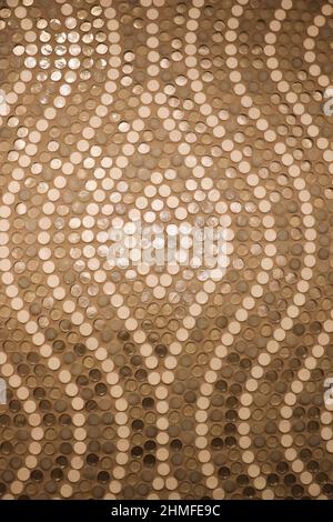 multi colored dot tiles in a hourglass pattern on a bathroom wall Stock Photo