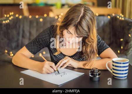 Good morning. Calligrapher Young Woman writes phrase on white paper. Inscribing ornamental decorated letters. Calligraphy, graphic design, lettering Stock Photo