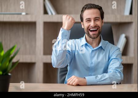 A manager in a blue shirt feeling joyful and happy Stock Photo