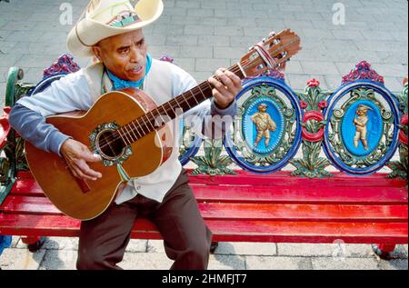 San Antonio Texas,Market Square,El Mercado troubadour guitar player Hispanic man ornate bench,La Margarita Mexican Restaurant & Oyster Bar Stock Photo