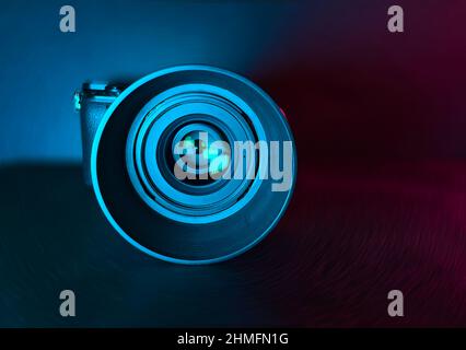 Professional Camera With Lens On Back Surface With Colored Lights Photography Concept Stock Photo