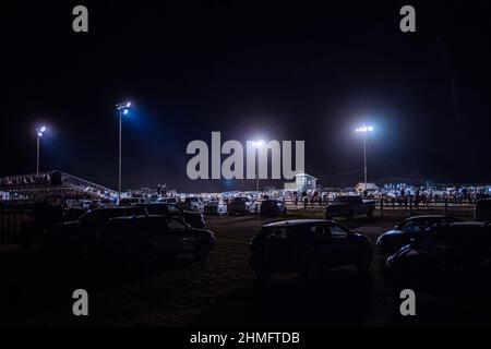 Rodeo Arena with lights on at night during summer from parking lot Stock Photo