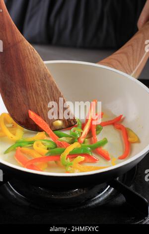 Stir Fry Paprika on Black Pan, Cooking Process in the Kitchen making Delicious Food like Korean Japchae, Chinese Beef Black Pepper, or Italian Peperon Stock Photo