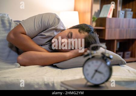 Young Asian man sleeping in bed Stock Photo