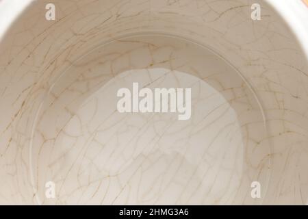 cracked glaze on the bottom of a white ceramic cup Stock Photo