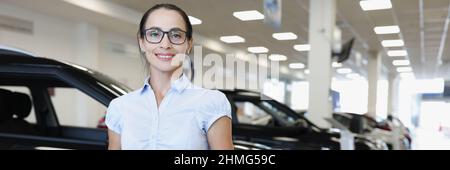 Portrait of smiling woman in glasses of car sales manager Stock Photo