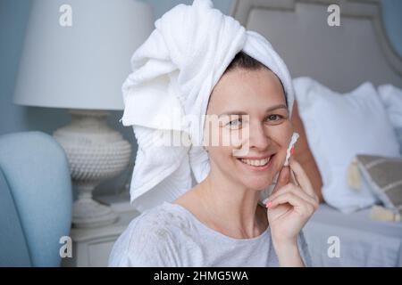 Close-up 35 year old woman taking care clean skin and pores after shower, holding cotton pad, using gel, bi-phase cleanser, removing make-up and dirt, enjoying effective beauty treatment. Stock Photo