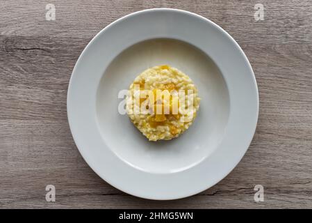 Italian Pumpkin Risotto isolated on wooden background Stock Photo