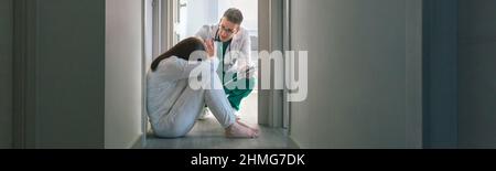 Doctor trying to help female patient with mental disorder who refuses help in the hospital Stock Photo