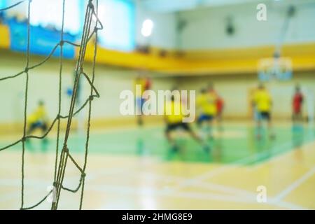 Sport mesh on blurred background of volleyball game, indoor. Teamwork concept, selective focus. Stock Photo