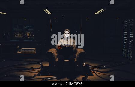 hacker with white mask sitting in an armchair with a computer Stock Photo