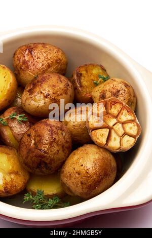 Baked potato in a clay pot isolated on white background Stock Photo