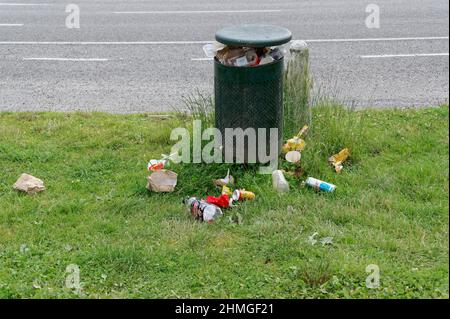 Too much rubbish has been stuffed into a rubbish bin that is now overflowing Stock Photo