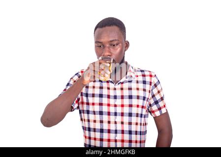 handsome adult man standing in shirt drinking a glass of ice beer. Stock Photo