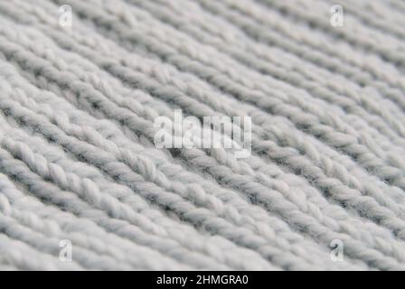 Close-up of hand-knitted garment (2x2 rib stitch) in pale blue. Diagonal view. Stock Photo