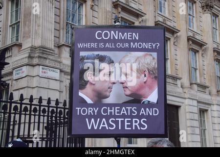 London, UK. 9th February 2022. A protester outside Downing Street holds an anti-Tory placard with images of Rishi Sunak and Boris Johnson. Protesters gathered in Westminster as pressure continues to mount on Boris Johnson over the Partygate scandal. Stock Photo