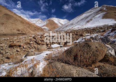 Road to Rumbak Valley and Yarutse, Hemis NP, Ladak, India. River with snow during winter, Himalayas. Mountain landscape in India wild nature. Sunny da Stock Photo