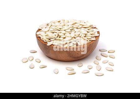 Pumpkin seeds in shell isolated on white background. Unpeeled pumpkin seeds in wooden bowl top view. Stock Photo