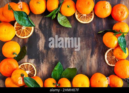 Frame of fresh ripe tangerines with leaves, on wooden background, top view, copy space Stock Photo