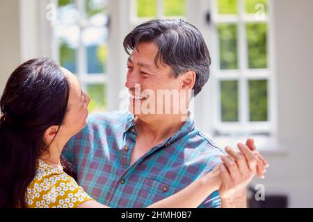 Loving Mature Couple On Summer Vacation Dancing Together In Holiday Apartment Stock Photo