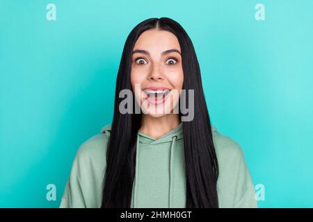 Photo of impressed millennial black hairstyle lady wear green hoodie isolated on teal color background Stock Photo