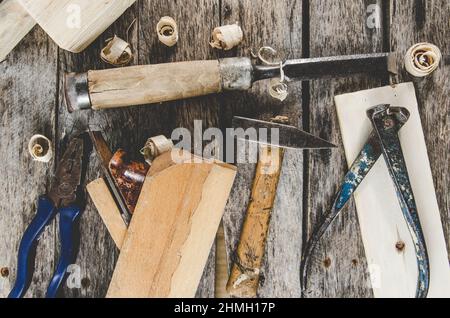 The carpenter tools on a wooden bench, a planer, chisel, hammer, tongs, top view Stock Photo